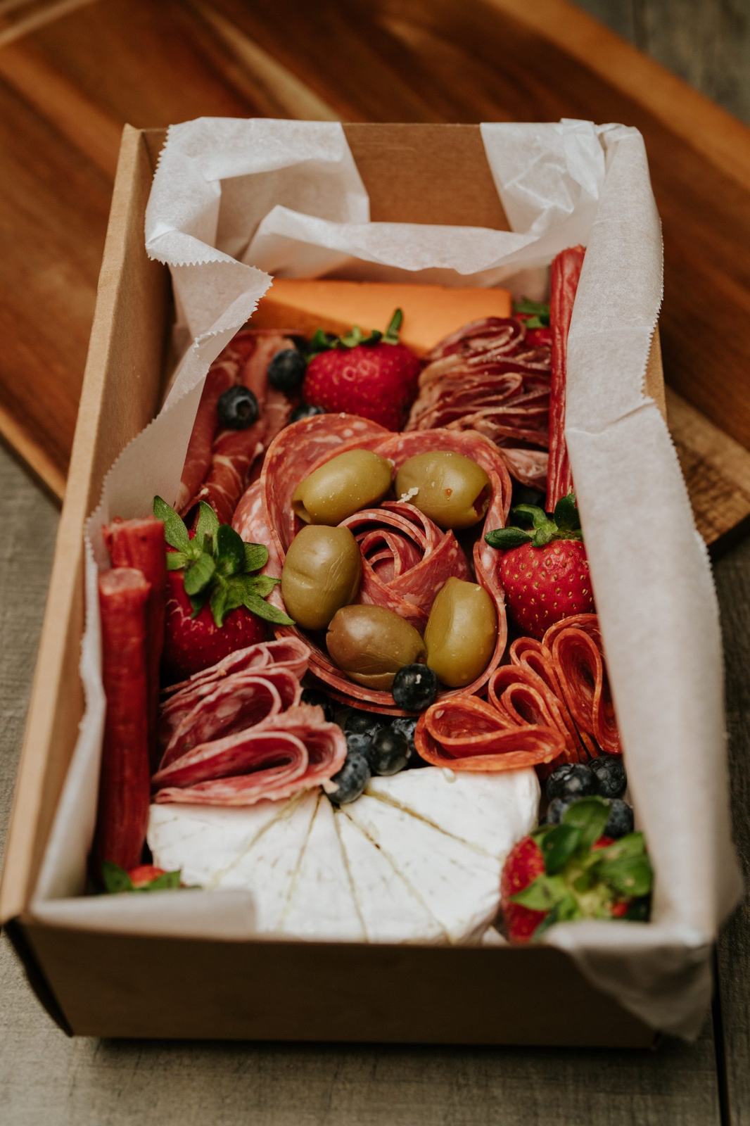 A charcuterie box of cured meats, olives and cheese