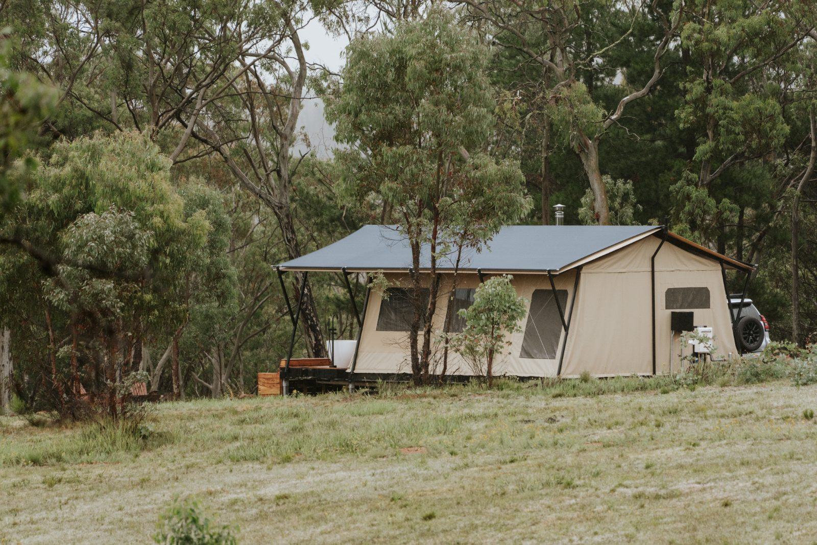The glamping tent in its grassy bushland clearing