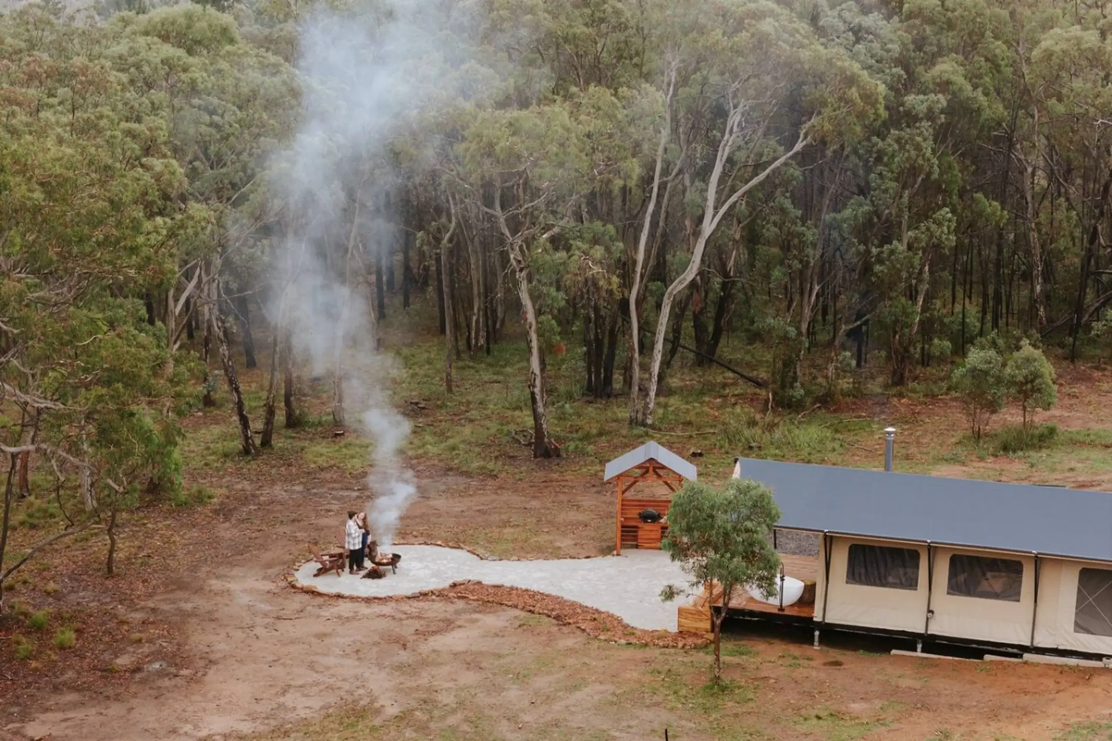 Golden-hour fire by the tent, seen from above