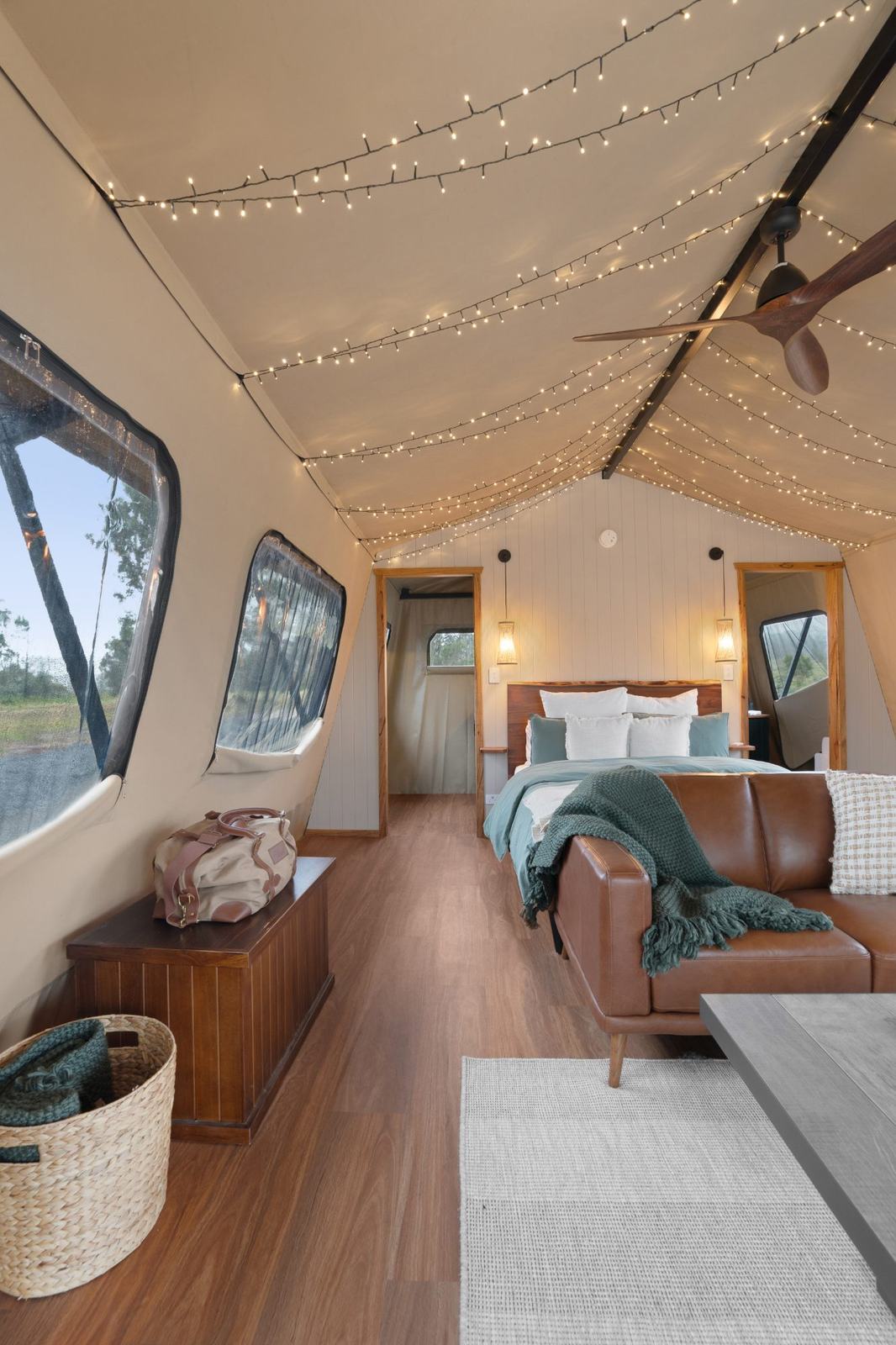 Glamping tent bedroom glowing with fairy lights