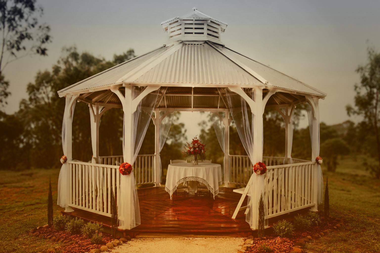 Open-air gazebo beside rows of cut flowers