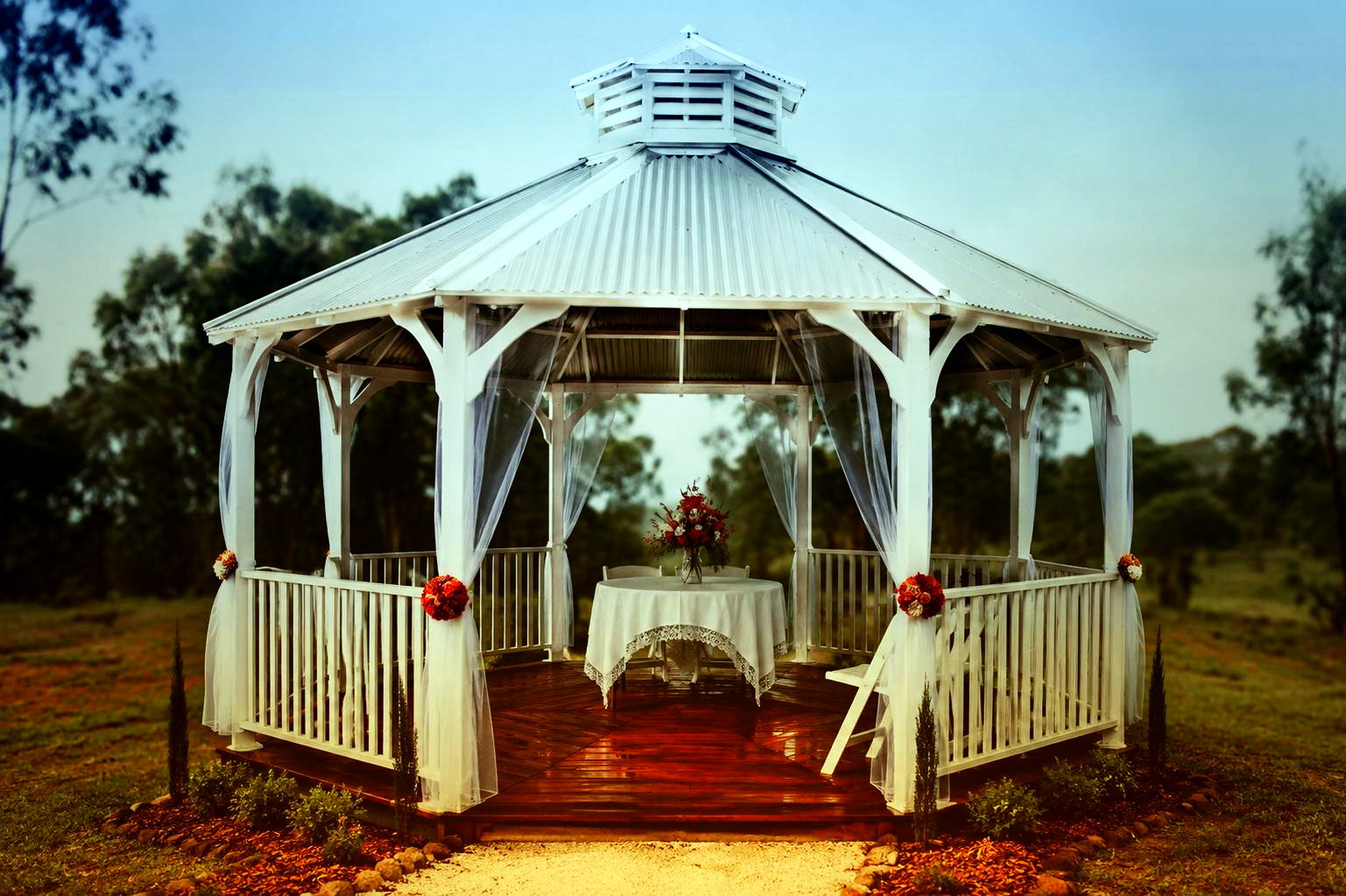 Open-air gazebo beside rows of cut flowers